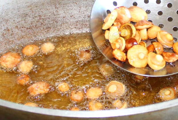 Шумовкой вынимаем грибы, обжаренные во фритюре